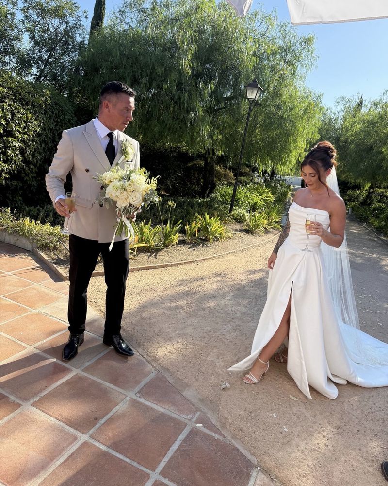 Bride and groom with champagne in a sunny garden
