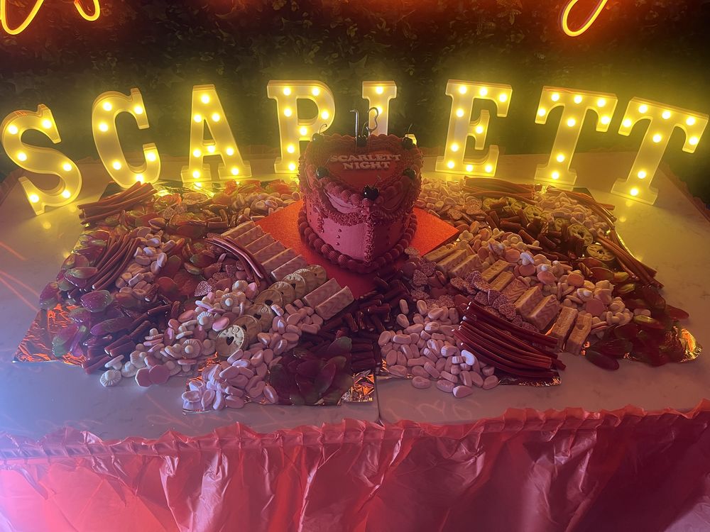 Light-up letters behind a sweet table and heart cake